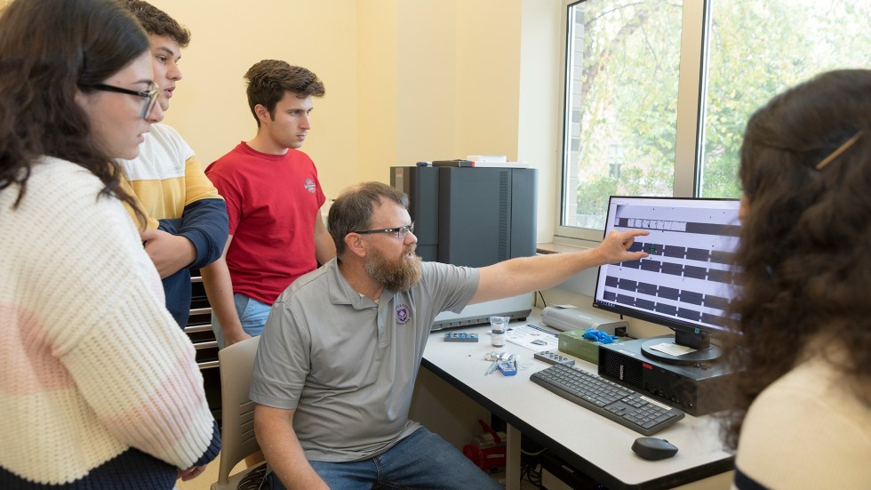 Faculty working with students in the lab