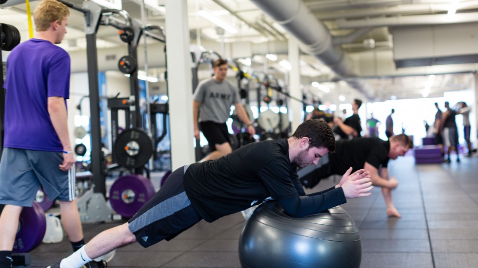 Student using medicine ball to exercise.