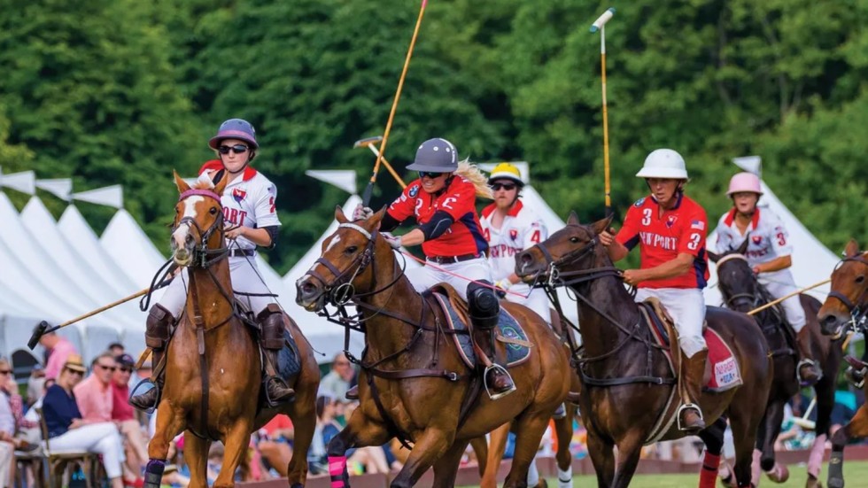 Photo of a polo match ont the Newport Polo grounds with five horses and five polo players.