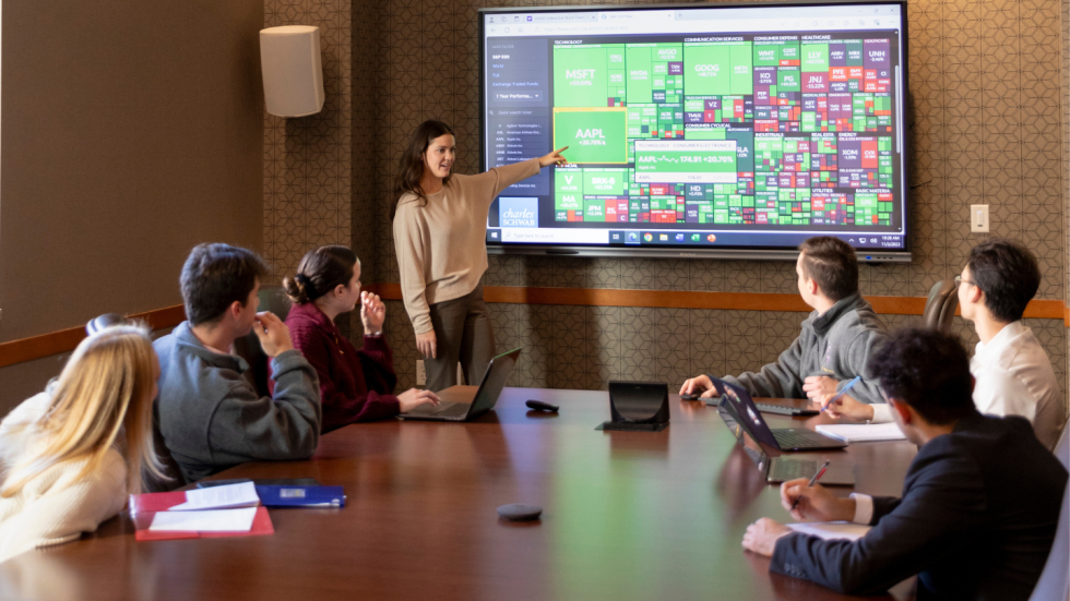 Students in Meehan Board Room with presentation on large monitor
