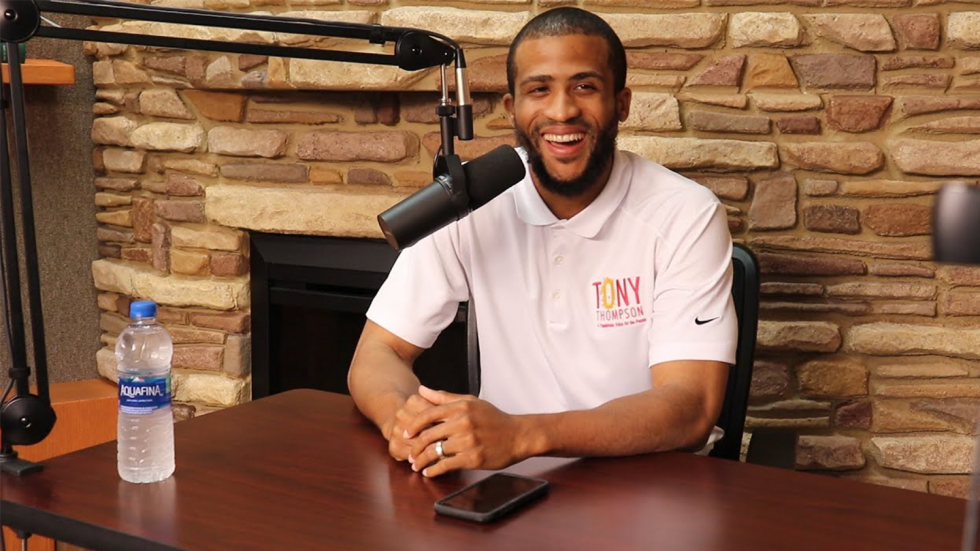 Tony Thompson seated at desk in front of microphone