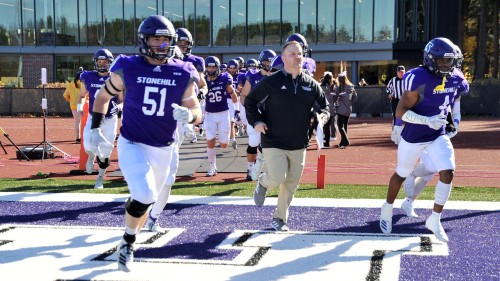 Stonehill football players running on to field