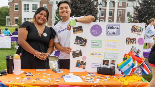Two students at table with poster board describing Latinx Club