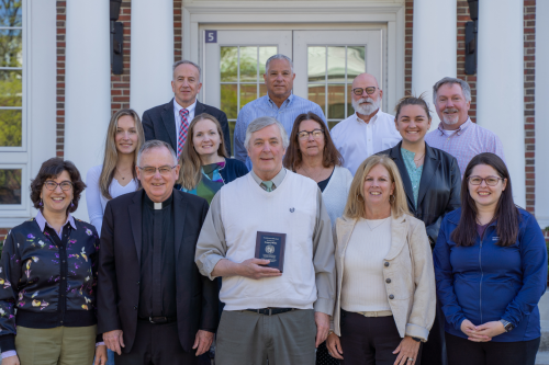 Director of Purchasing Gregory Wolfe (center) is joined by senior administrators and members of the Environmental Stewardship Council on the steps of Meehan Hall.
