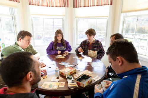 A group of people sitting around a table playing a game.