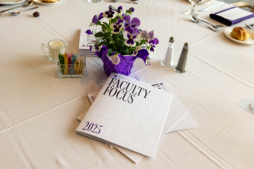 Faculty Focus book on table with whitetable cloth; flowers are next to the book.