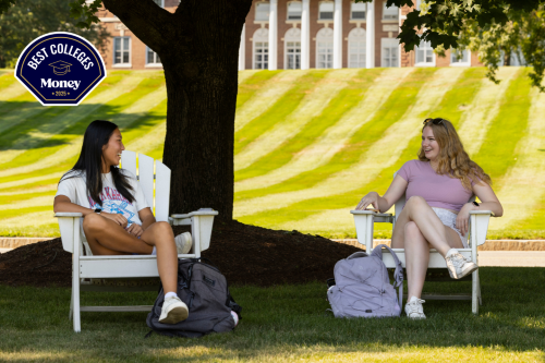 Two students sitting under a tree.