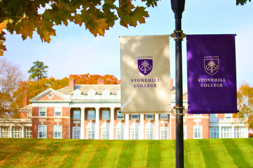 Stonehill College banner in front of Donahue Hall