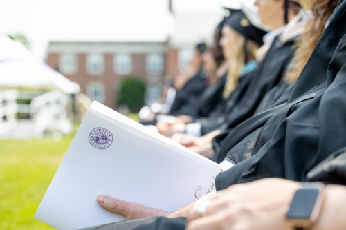 Students photographed slightly out of focus, seated at Commencement.