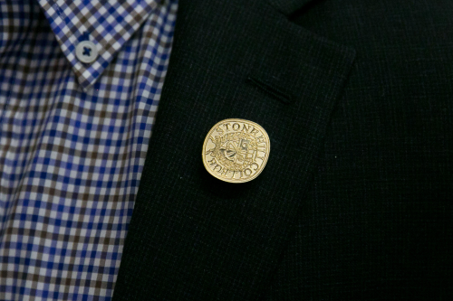 Convocation pin on lapel.