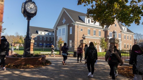 Students walking by clock.