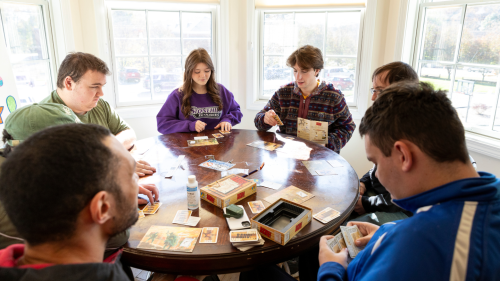 A group of people sitting around a table playing a game.