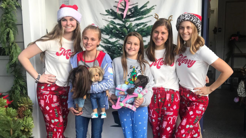 A pair of kit & sis customers pose for a holiday photo with company co-founders Kate Lally '24 (left), Madeline Pollock (center) and Gabrille Pollock (right).
