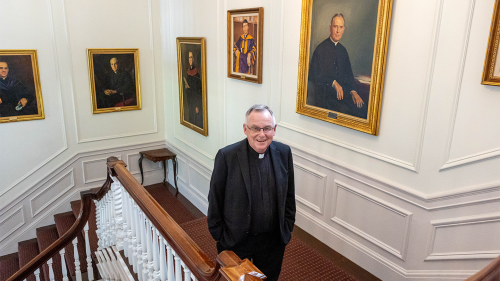 Fr. Denning, the 10th president of Stonehill, walks by portraits of his predecessors each day on the way to his office, located in Donahue Hall.