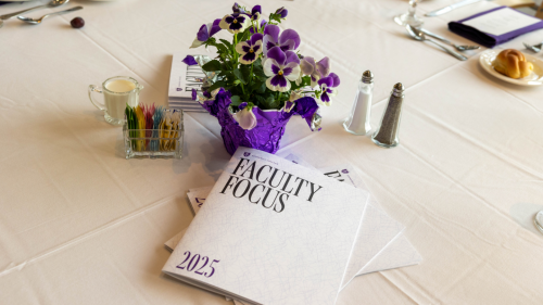 Faculty Focus book on table with whitetable cloth; flowers are next to the book.