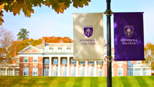 Stonehill College banner in front of Donahue Hall