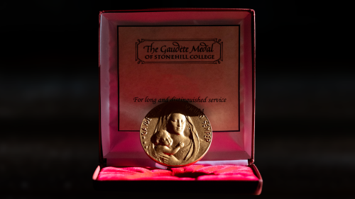 Gaudete Medal of Stonehill College in open case.