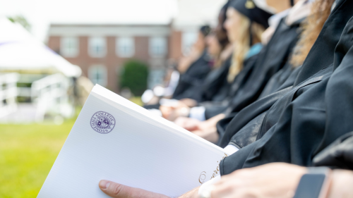 Students photographed slightly out of focus, seated at Commencement.