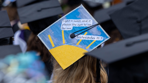 Commencement hat with image of Sun against sky, with quote from Ecclesiastes 11:7 - "Light is sweet, and it pleases the eyes to see the sun."