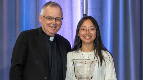 Rev. John Denning, C.S.C. presents the President's Cup to Ula Nguyen '26.