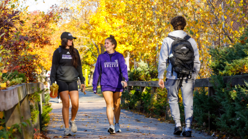 Students walking on campus on autumn day.