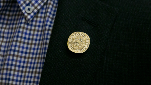 Convocation pin on lapel.