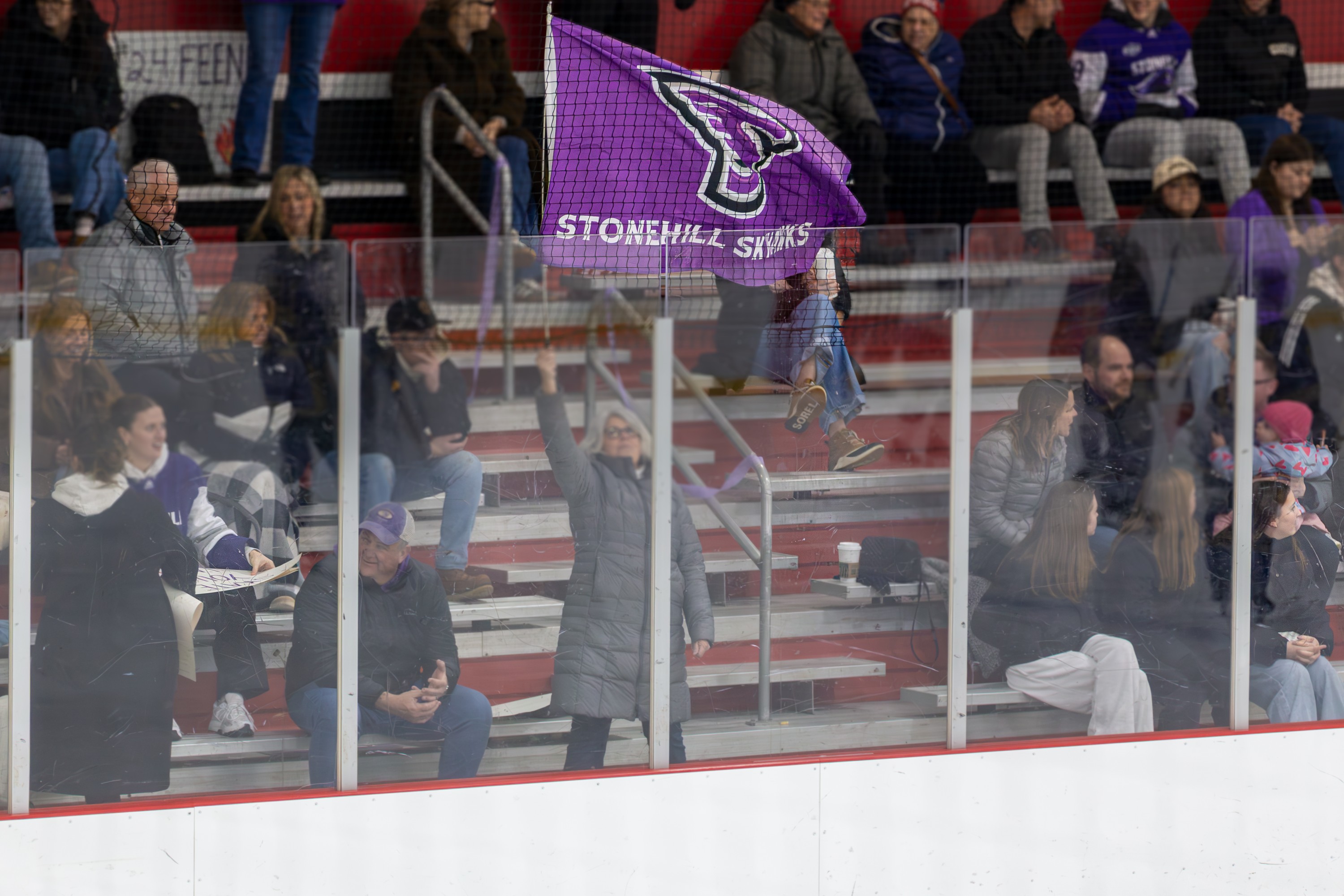 Hockey fan waving Stonehill Skyhawks flag